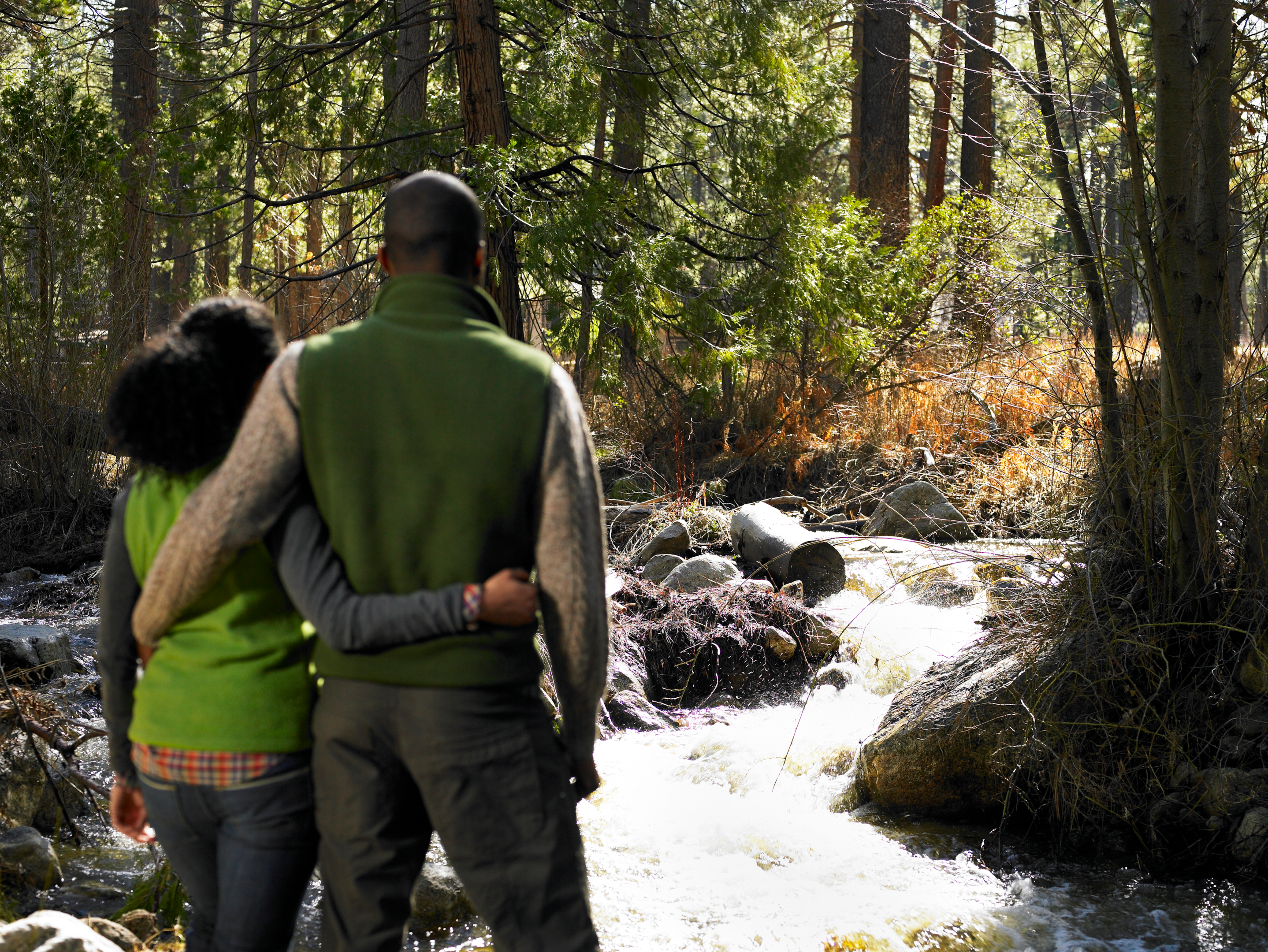 Couple standing in front of a fishing trail downstream