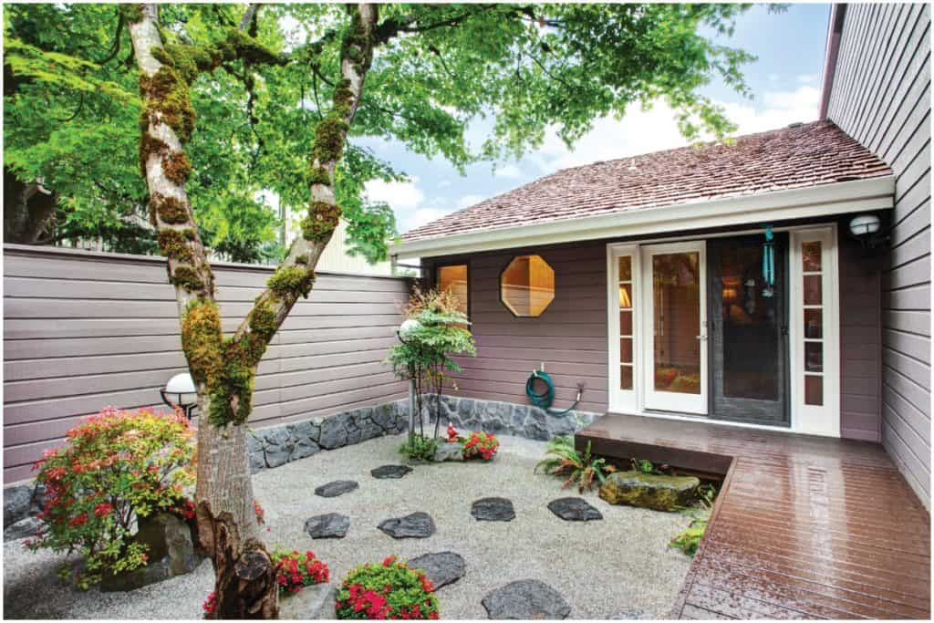 backyard porch with a rock garden and large tree