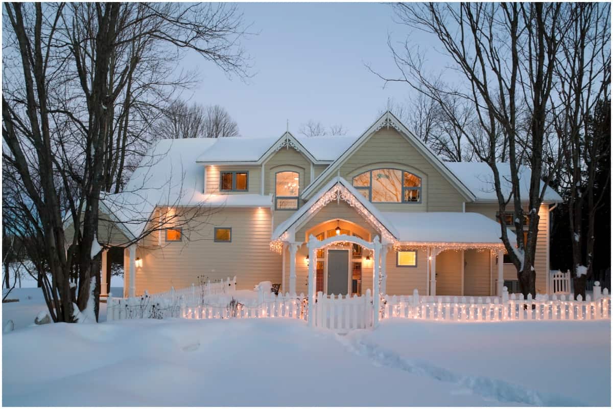 snowy winter home with holiday lights