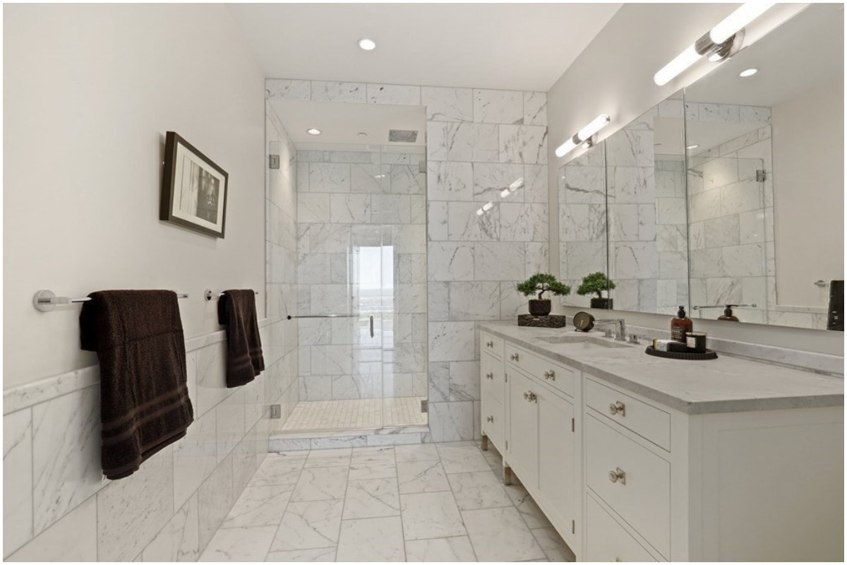 A white bathroom with vanity and shower