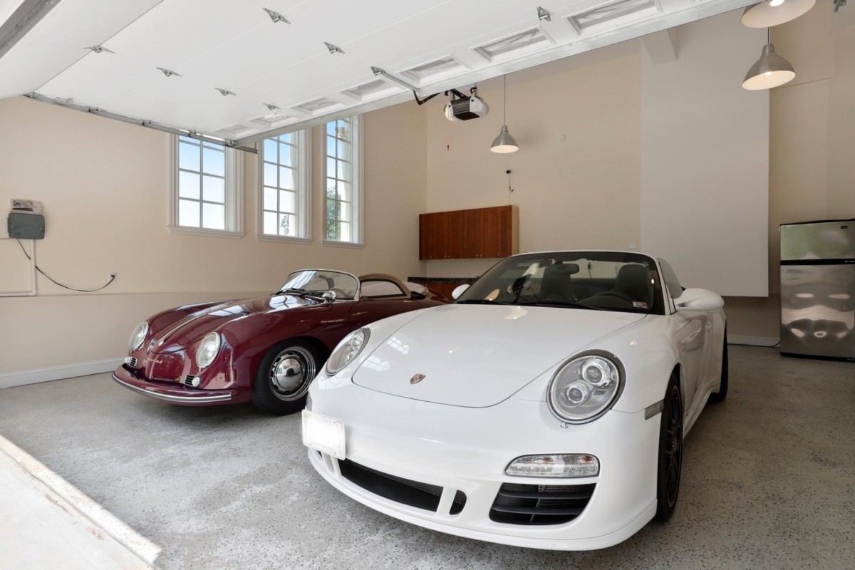 garage with expensive white car and vintage maroon car