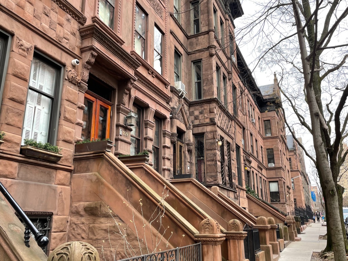 brownstone row houses on a cloudy street with stoops