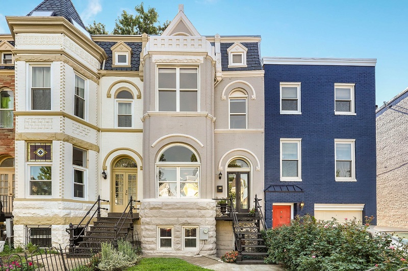 queen anne style row house with a blue row house on the right