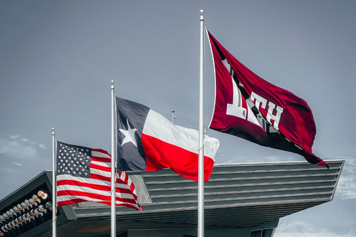 Three flags in front of a stadium