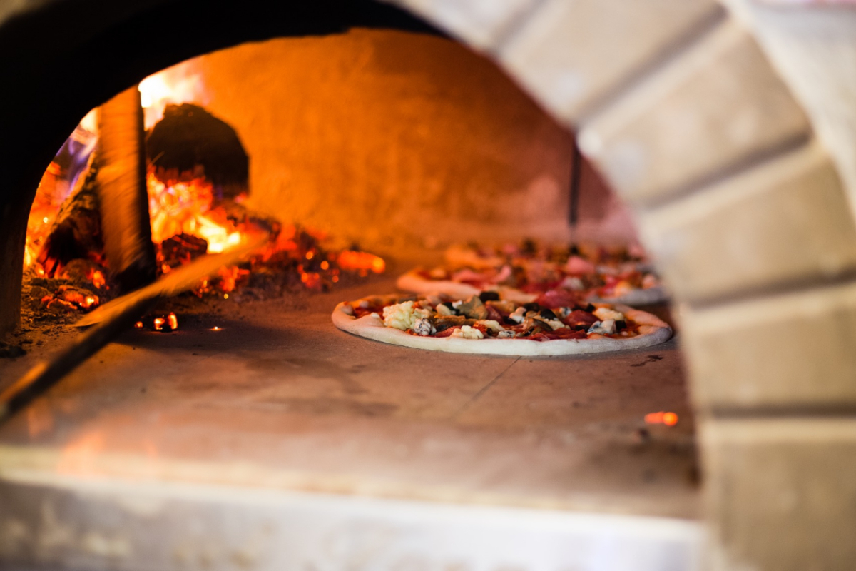 A pizza in a woodfire oven