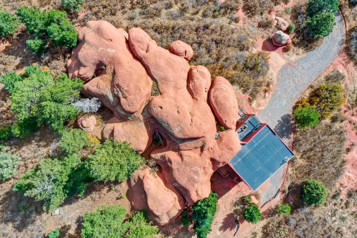 aerial view of a home in southwestern north america next to a large rock feature