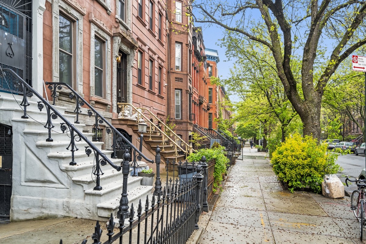 row of brownstone homes on tree-lined street