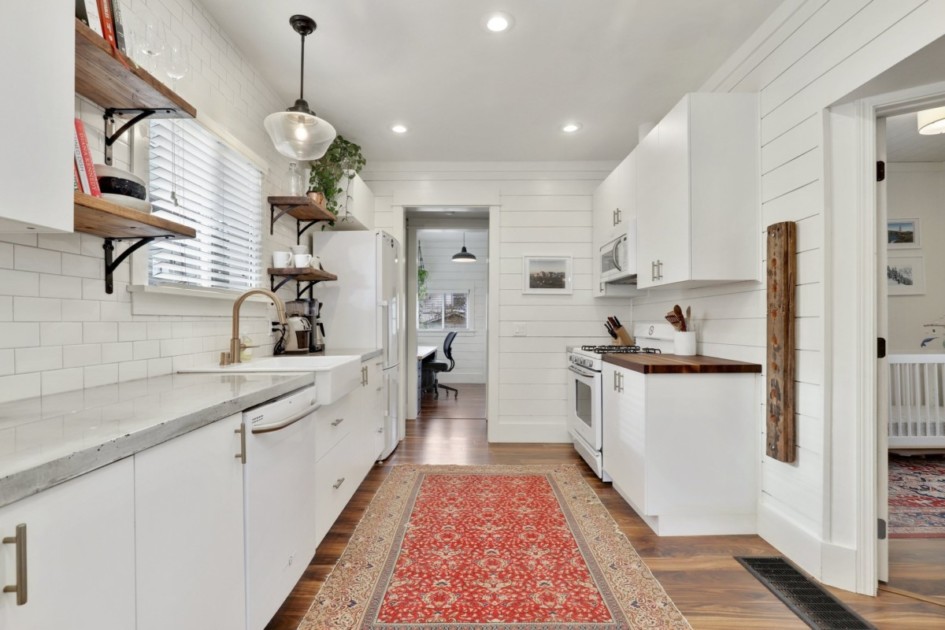 A white kitchen with a red runner rug