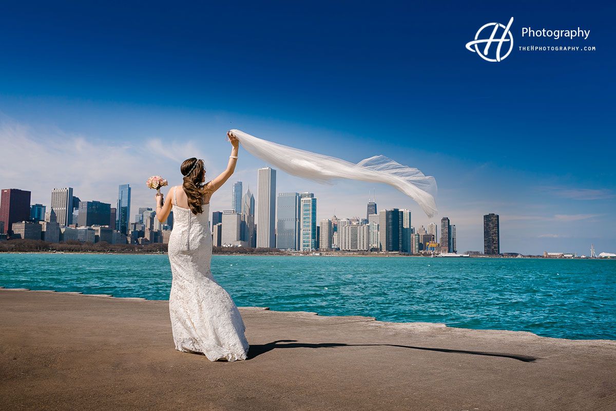 A bride throwing her veil with Chicago behind her