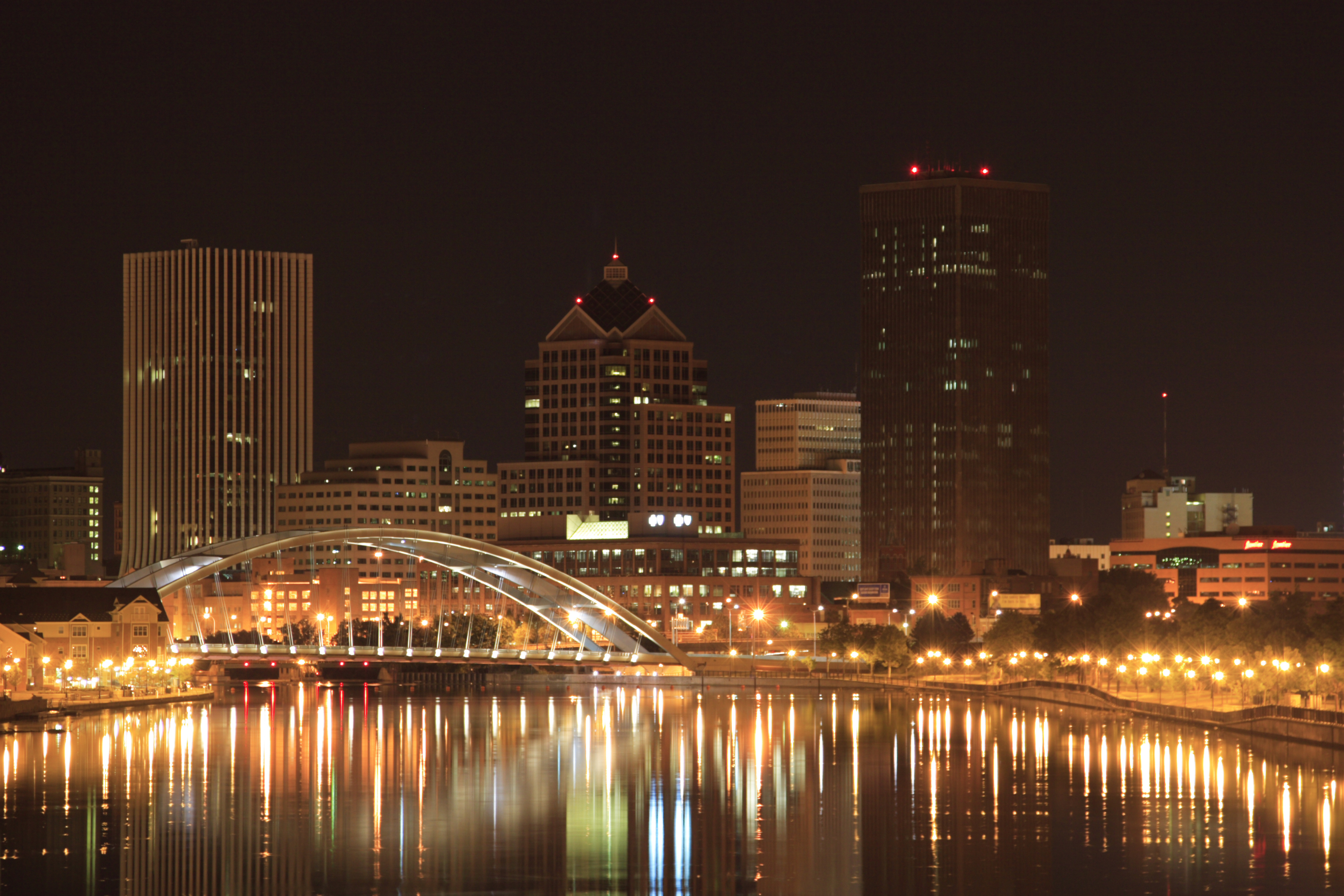 Rochester, NY downtown at night with the city reflecting off of the Genesee river.