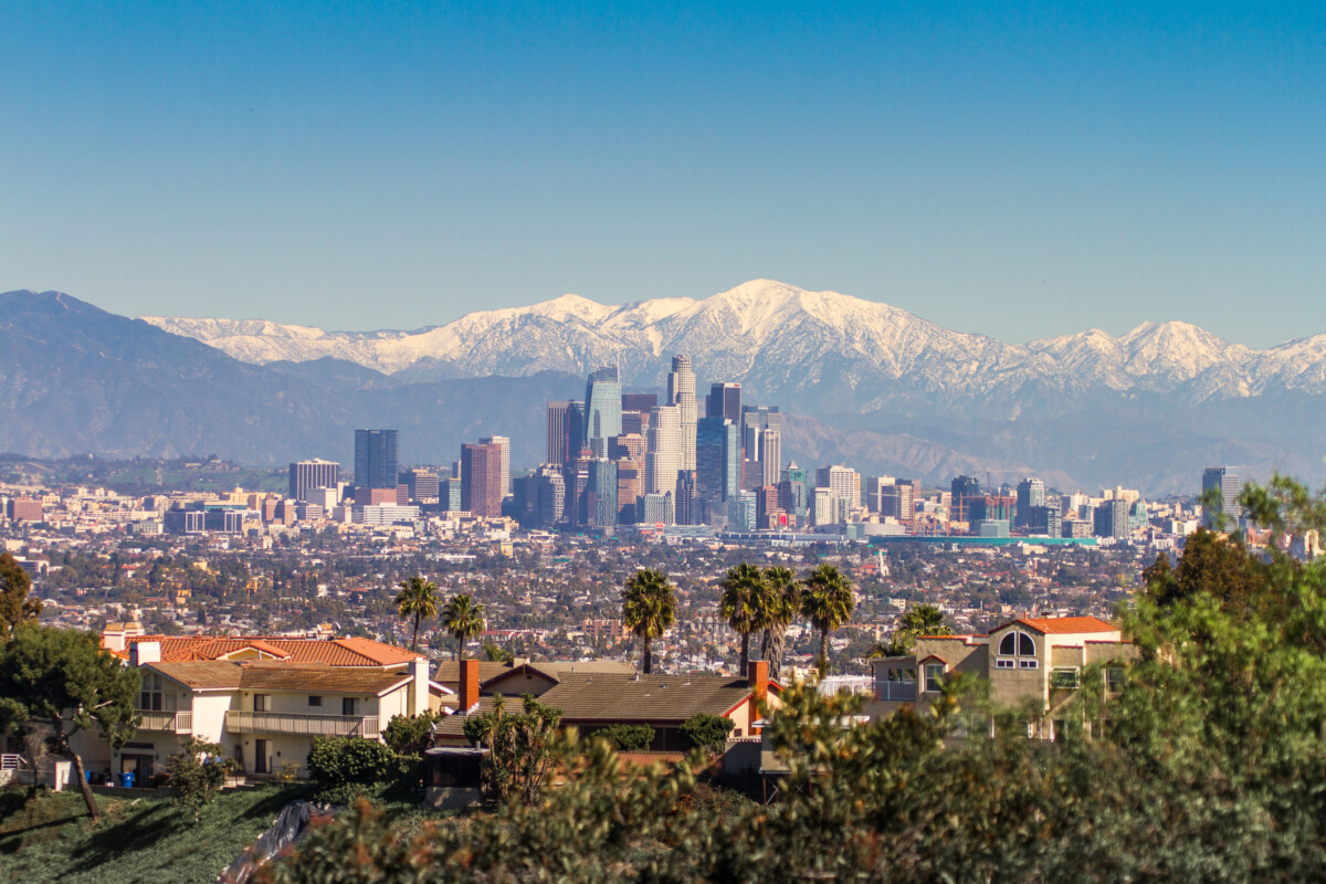Snowed peaks mountains and downtown Los Angeles cityscape