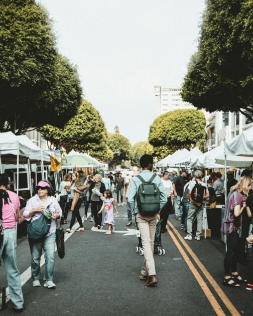 A downtown festival with people walking along booths